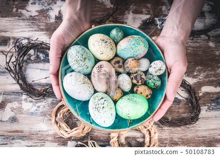 Easter composition. Female hands holding a plate Easter composition. Female hands holding a plate 50108783