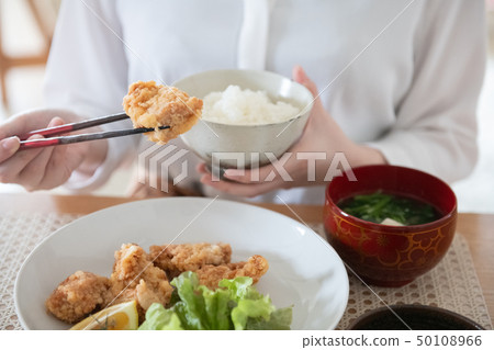 Hand of young woman eating fried chicken Hand of young woman eating fried chicken 50108966