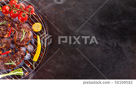 Barbecue grill with beef steaks, close-up. 50109582