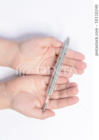 Little boy holding a thermometer in his hands on a 50110248