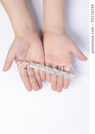 Little boy holding a thermometer in his hands on a 50110249
