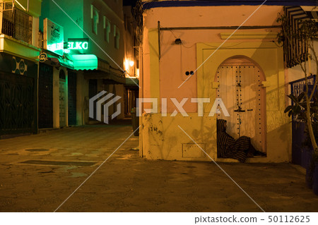 Man in Traditional moroccan djellaba walking on the street of Asilah Medina, on Atlantic Coast in 50112625