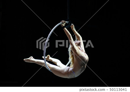 Graceful aerial acrobat doing her performance with a hoop isolated on black Graceful aerial acrobat doing her performance with a hoop isolated on black 50113041