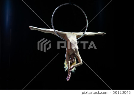 Graceful aerial acrobat doing her performance with a hoop isolated on black Graceful aerial acrobat doing her performance with a hoop isolated on black 50113045