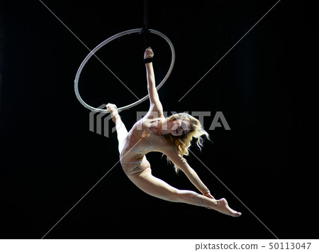 Graceful aerial acrobat doing her performance with a hoop isolated on black Graceful aerial acrobat doing her performance with a hoop isolated on black 50113047