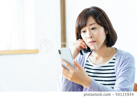 Mother using a smart phone middle woman full-time housewife Mother using a smart phone middle woman full-time housewife 50115934