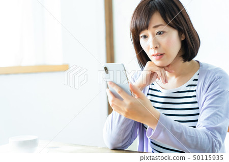 Mother using a smart phone middle woman full-time housewife Mother using a smart phone middle woman full-time housewife 50115935
