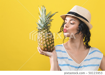 Happy young woman holding a pineapple Happy young woman holding a pineapple 50115953