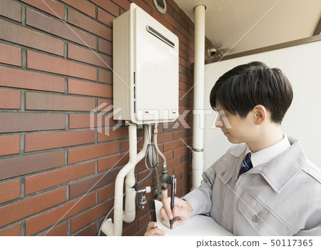 Businessman checking house water heater 50117365