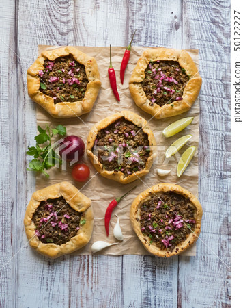Open meat pies on a black background. Top view. Open meat pies on a black background. Top view. 50122227