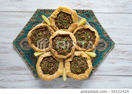 Arabian opened meat pies on white wood background. Arabian opened meat pies on white wood background. 50122424