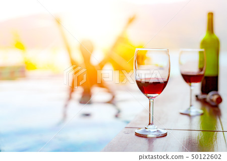 Two glasses of red wine near the swimming pool Two glasses of red wine near the swimming pool 50122602