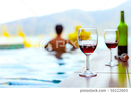 Two glasses of red wine near the swimming pool Two glasses of red wine near the swimming pool 50122603