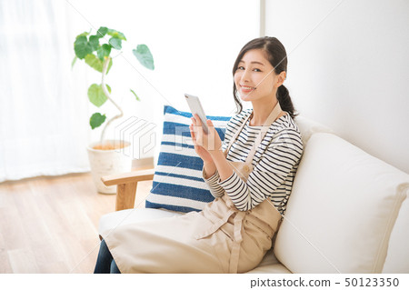 A housewife watching a smartphone A housewife watching a smartphone 50123350
