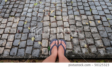 Woman foot on stone path Woman foot on stone path 50125323