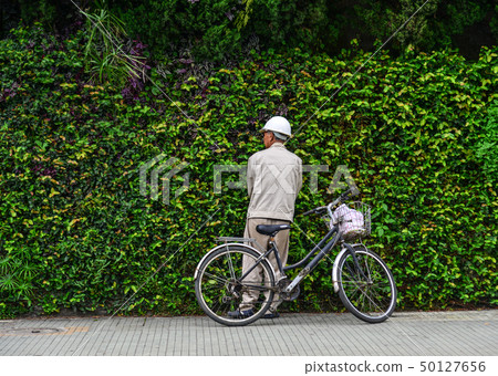 Old man with his old bike on the street 50127656
