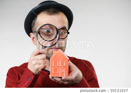 Man magnifying red house 50131837