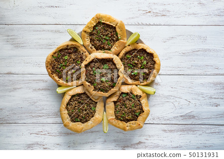 Arabian opened meat pies on white wood background. Arabian opened meat pies on white wood background. 50131931