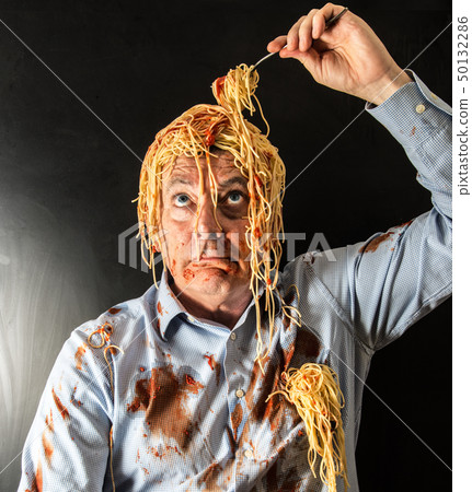 man eating spaghetti with tomato sauce in head 50132286