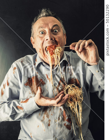 man eating spaghetti with tomato sauce 50132290