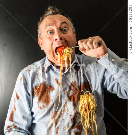 man eating spaghetti with tomato sauce 50132293