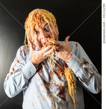 man eating spaghetti with tomato sauce in head 50132294