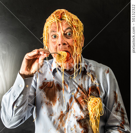 man eating spaghetti with tomato sauce in head 50132322