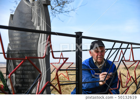 A man paints the fence on the monument A man paints the fence on the monument 50132619