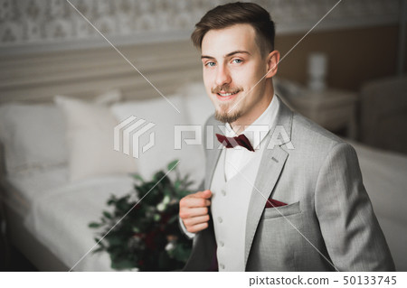 Grooms morning preparation. Handsome man getting dressed and preparing for the wedding 50133745