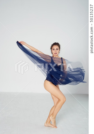 A slender gymnast in black tights dances with a blue chiffon that develops.Aesthetics of dance A slender gymnast in black tights dances with a blue chiffon that develops.Aesthetics of dance 50135237