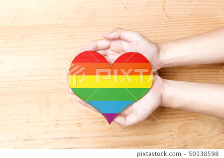 Human hands holding heart with rainbow flag 50138598
