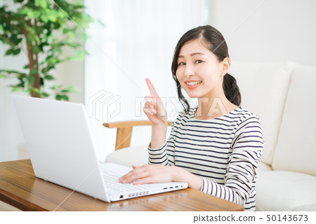 A woman who plays a personal computer in a room 50143673