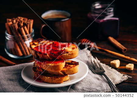 Stack of french toasts with berry syrup 50144352