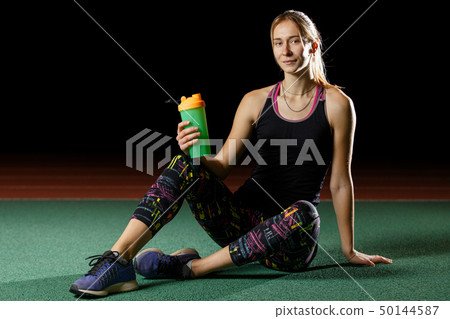 Young tired girl relaxing after fitness training 50144587