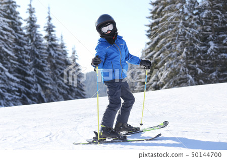 Small boy skiing on slope at mountain ski resort Small boy skiing on slope at mountain ski resort 50144700