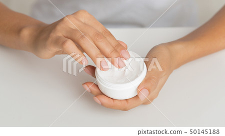 Woman holding jar of nourishing cream to protect skin 50145188