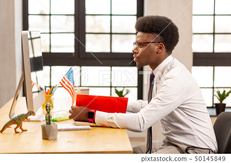 Intelligent young businessman focusing on his work 50145849