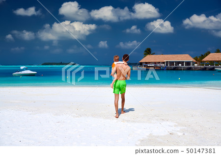 Toddler boy on beach with father 50147381