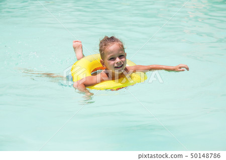 Baby boy is swimming in the pool  50148786