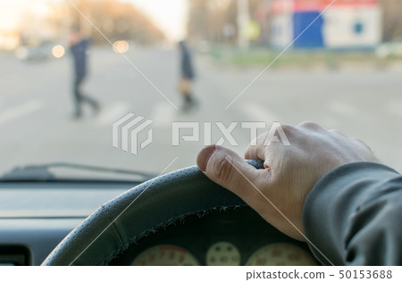 man's hand on the steering wheel 50153688