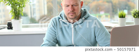 A young designer holds a pen from a tablet in his A young designer holds a pen from a tablet in his 50157071