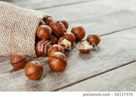 Macadamia nut on a wooden table in a bag, closeup, Macadamia nut on a wooden table in a bag, closeup, 50157370