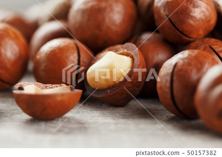 Macadamia nut on a wooden table in a bag, closeup, 50157382