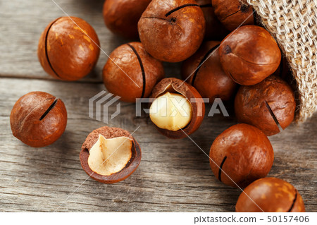 Macadamia nut on a wooden table in a bag, closeup, 50157406