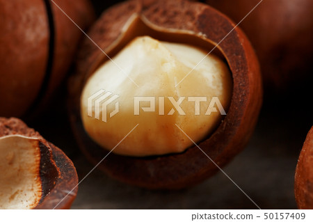 Macadamia nut on a wooden table in a bag, closeup, 50157409
