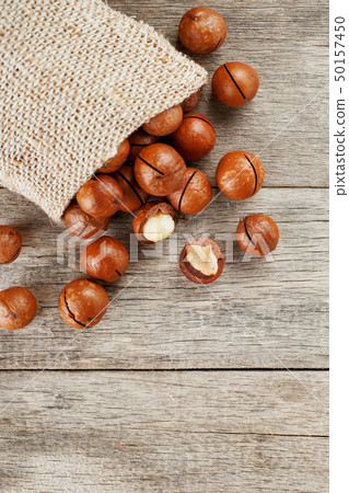 Macadamia nut on a wooden table in a bag, closeup, 50157450