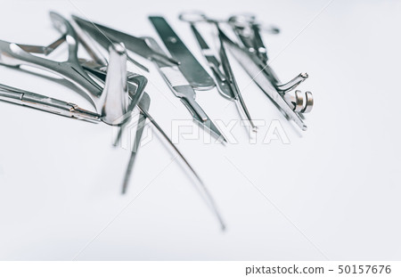 Several surgical instruments lie on a white table Several surgical instruments lie on a white table 50157676