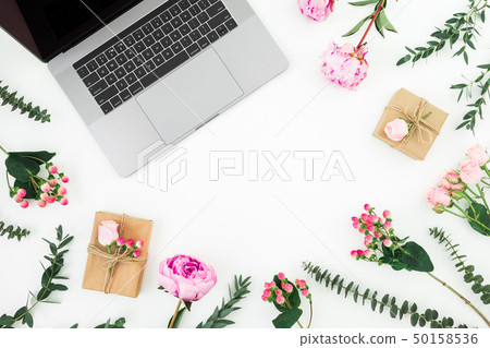 Office workspace with laptop and pink flowers Office workspace with laptop and pink flowers 50158536