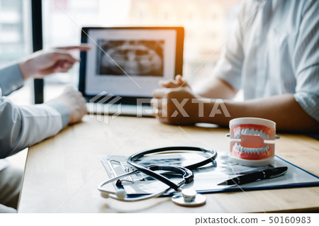 Dentist hand pointing x-ray picture in laptop Dentist hand pointing x-ray picture in laptop 50160983