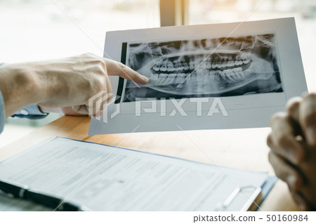 Dentist hand holding pen pointing x-ray picture Dentist hand holding pen pointing x-ray picture 50160984